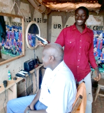 Burundi: Entrepreneur in Burundi who uses solar electricity in his kiosk, restaurant, for cutting hair and for charging cell phones and batteries. The owner received a subsidy and training from GIZ. Upon installation of the solar system, he hired two employees. <br />
© GIZ / Caroline Heidtmann